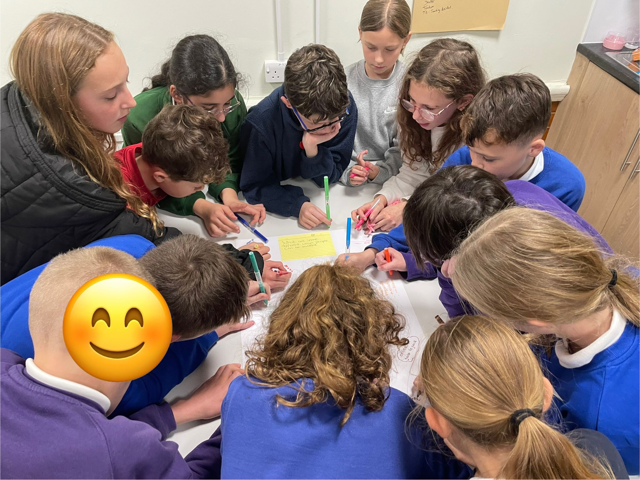 A photo shows children at SELFA children's charity working on a project together.