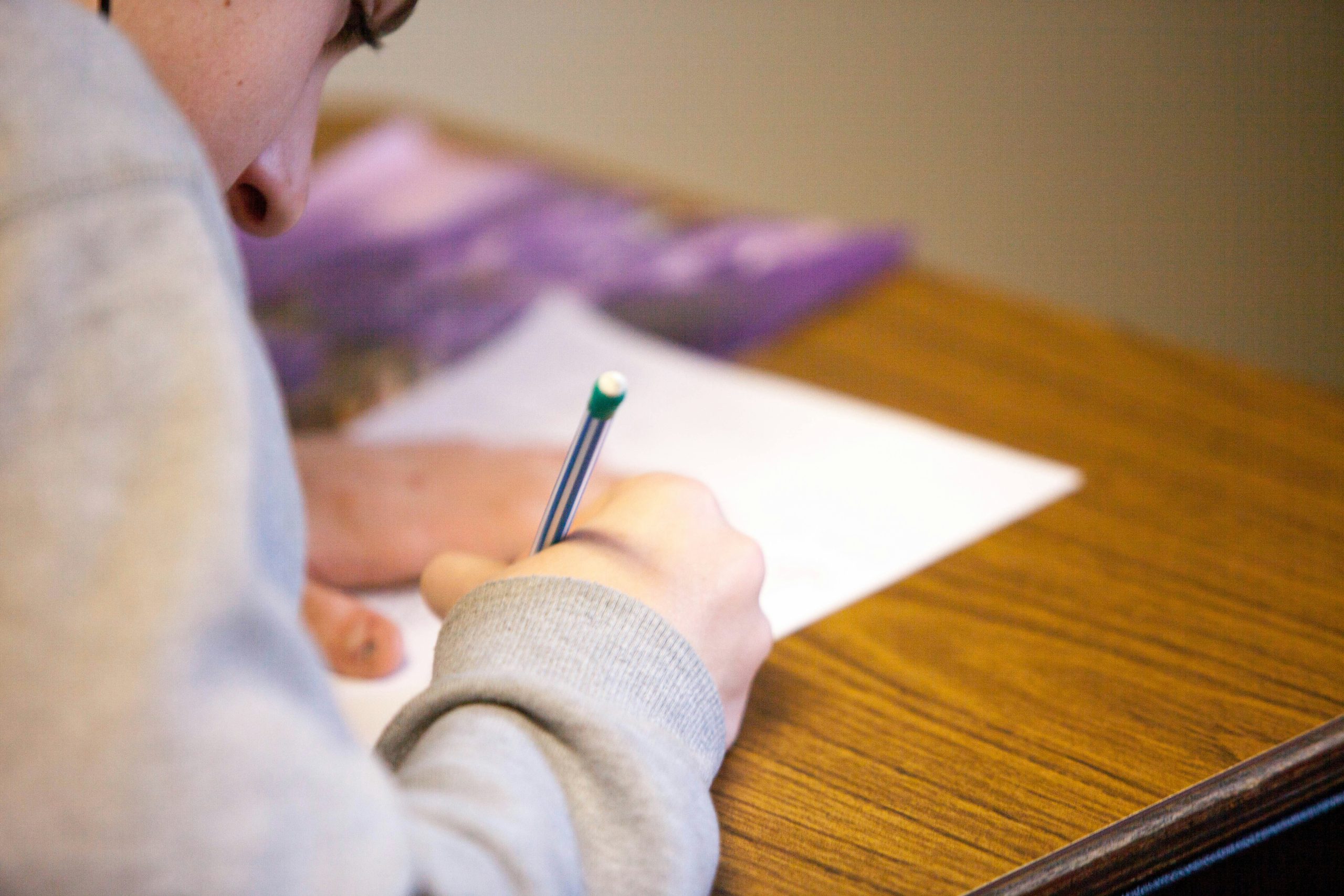 A stock image shows a child doing a school exam.
