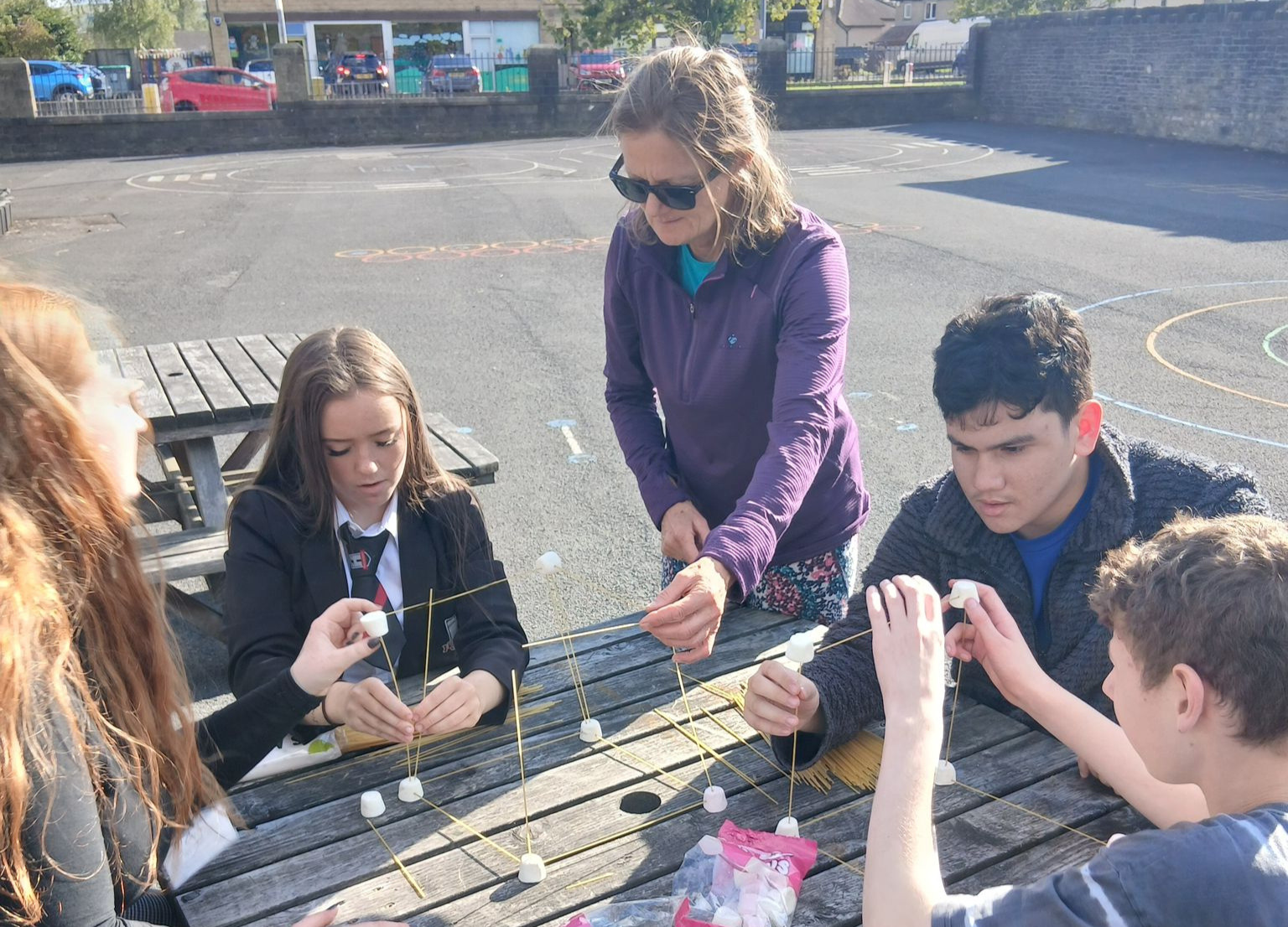 A photo of SELF volunteer Bridget helping young people with a team-building exercise.