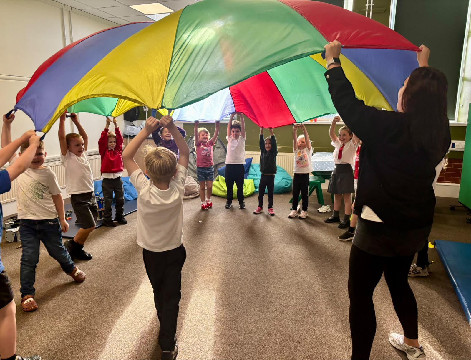 Children play with a colourful parachute at SELFA children's charity